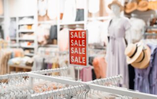 Sale in the women's section of a clothing store. Red sign with the inscription Sale, discount in